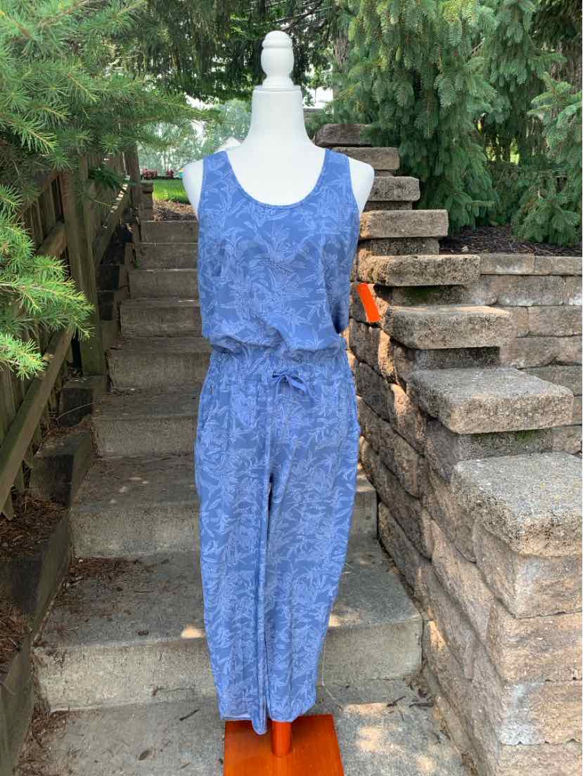 Blue sleeveless jumpsuit with subtle pattern, elastic waist, and scoop neckline.