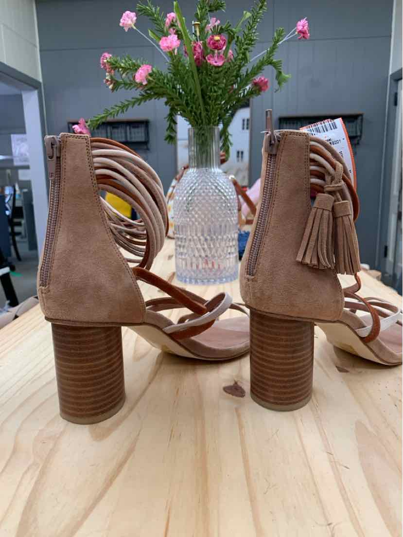 Tan suede block-heeled sandals with stacked wooden heels, ankle strap, and fringe tassel detailing.