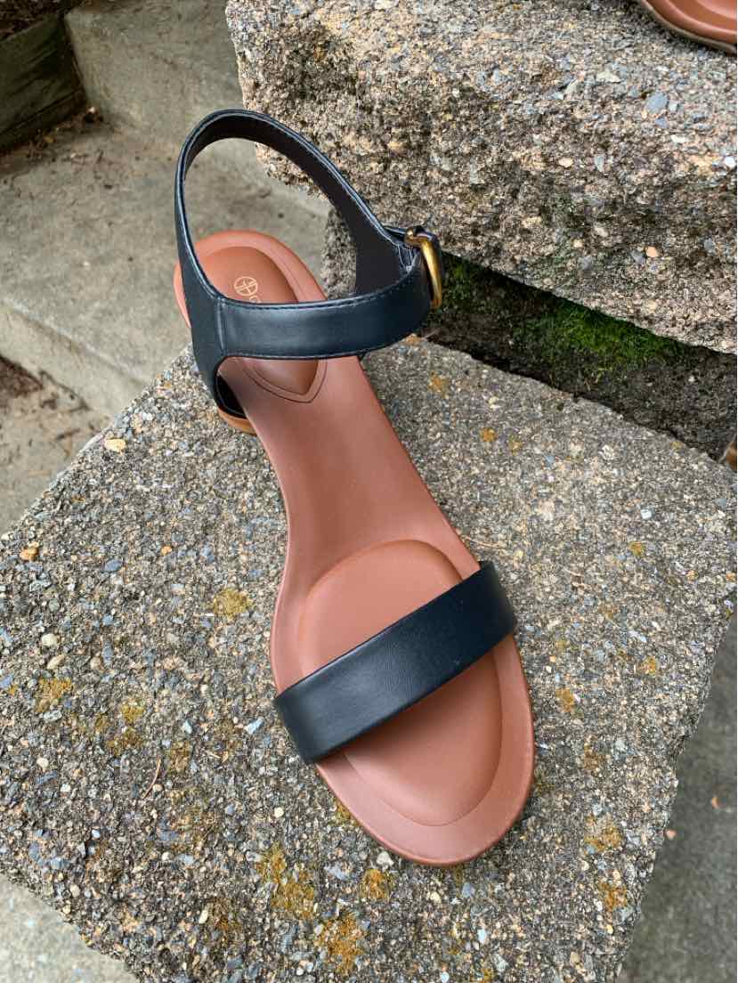 Black leather slingback sandal with open toe and tan cushioned footbed, size 11.
