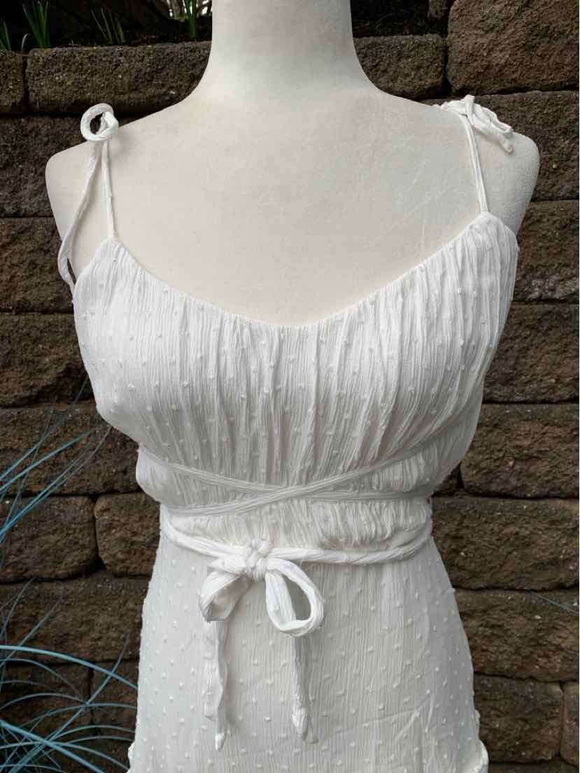 White sleeveless dress with adjustable tie straps and a front waist tie belt.