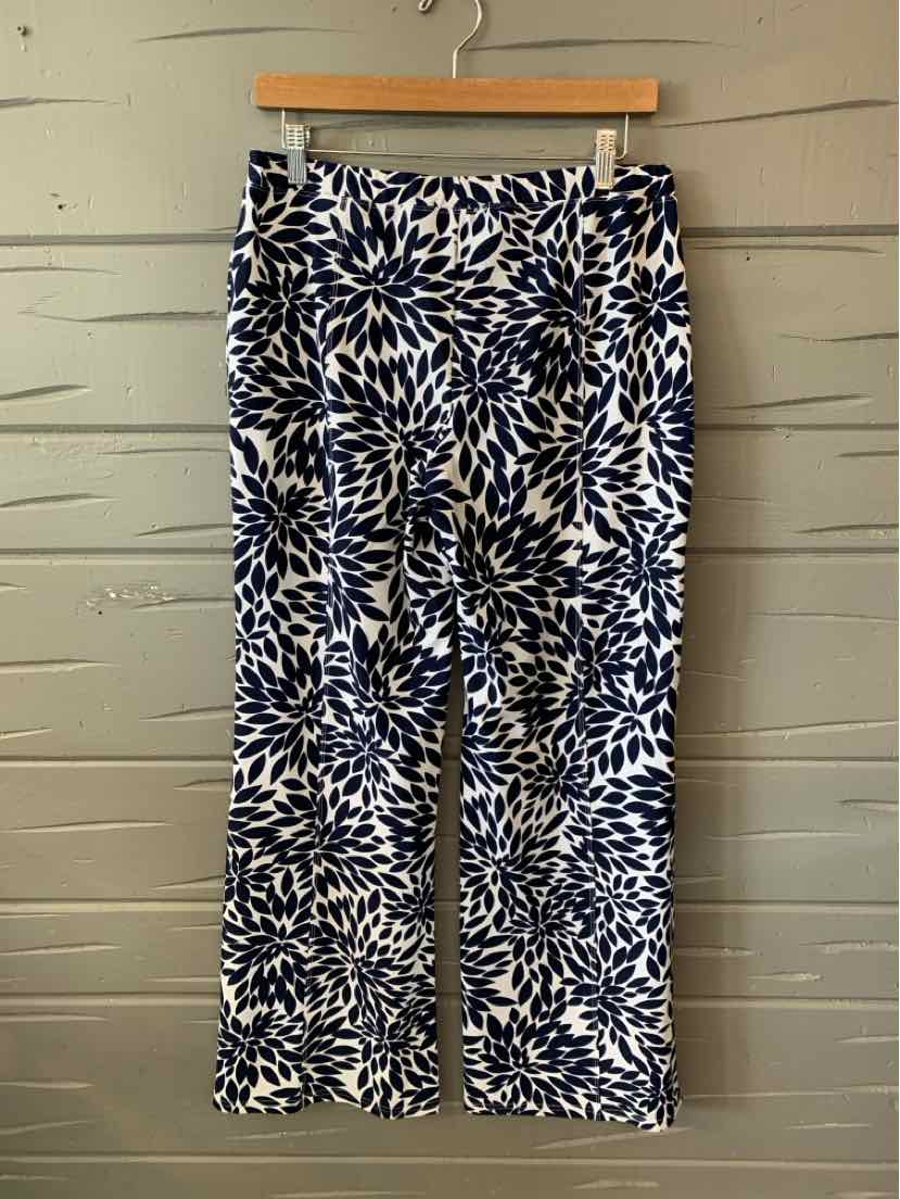 Navy blue and white wide-leg pants with abstract leaf pattern hanging on wooden hanger.