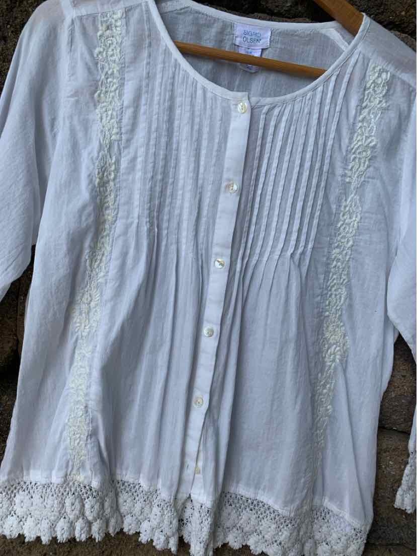 White long-sleeve blouse with front pintuck details, button closure, and lace embroidery trim.