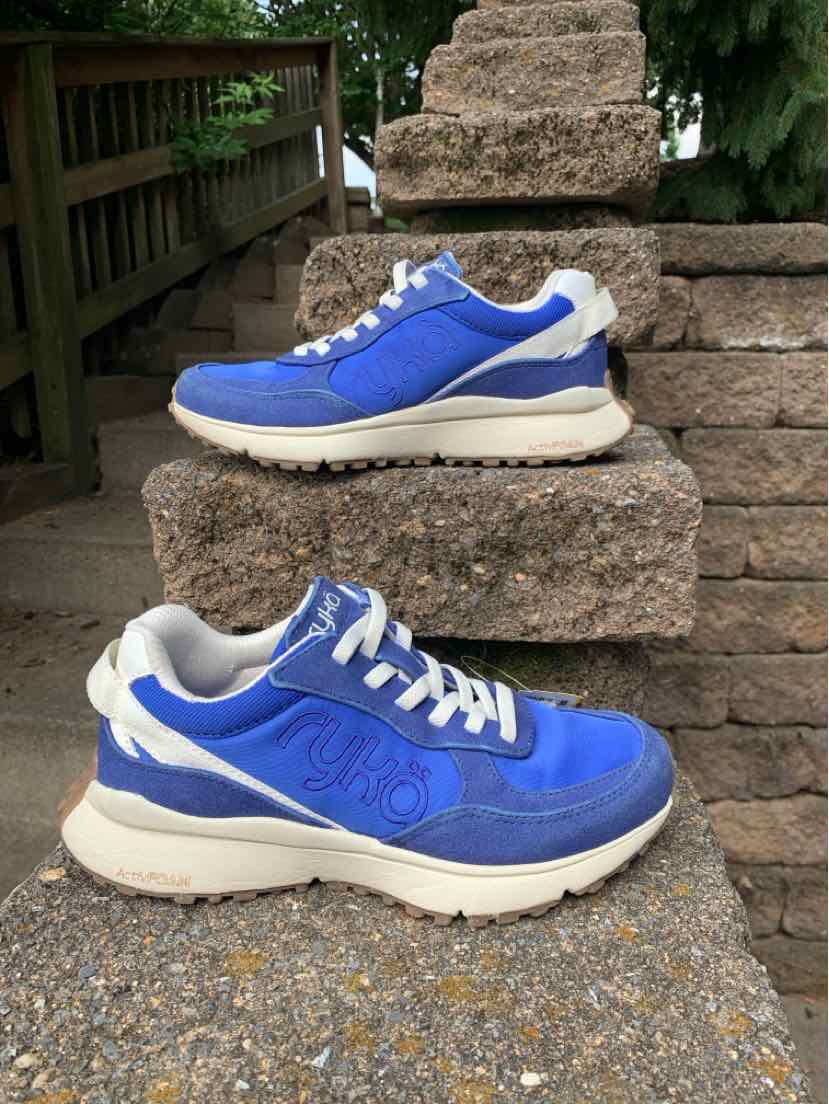 Blue women's sneaker with white laces and sole, cushioned collar, and breathable mesh upper.