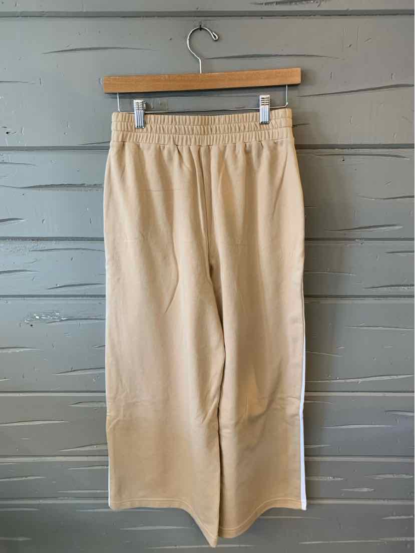 Tan wide-leg pants with elastic waistband and front pockets in size XS hanging on wooden hanger.