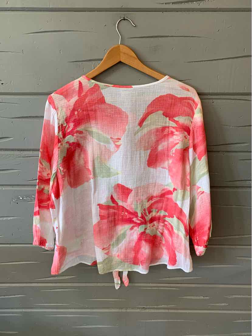 Lightweight white blouse with large pink and red floral print, long sleeves, and round neckline.