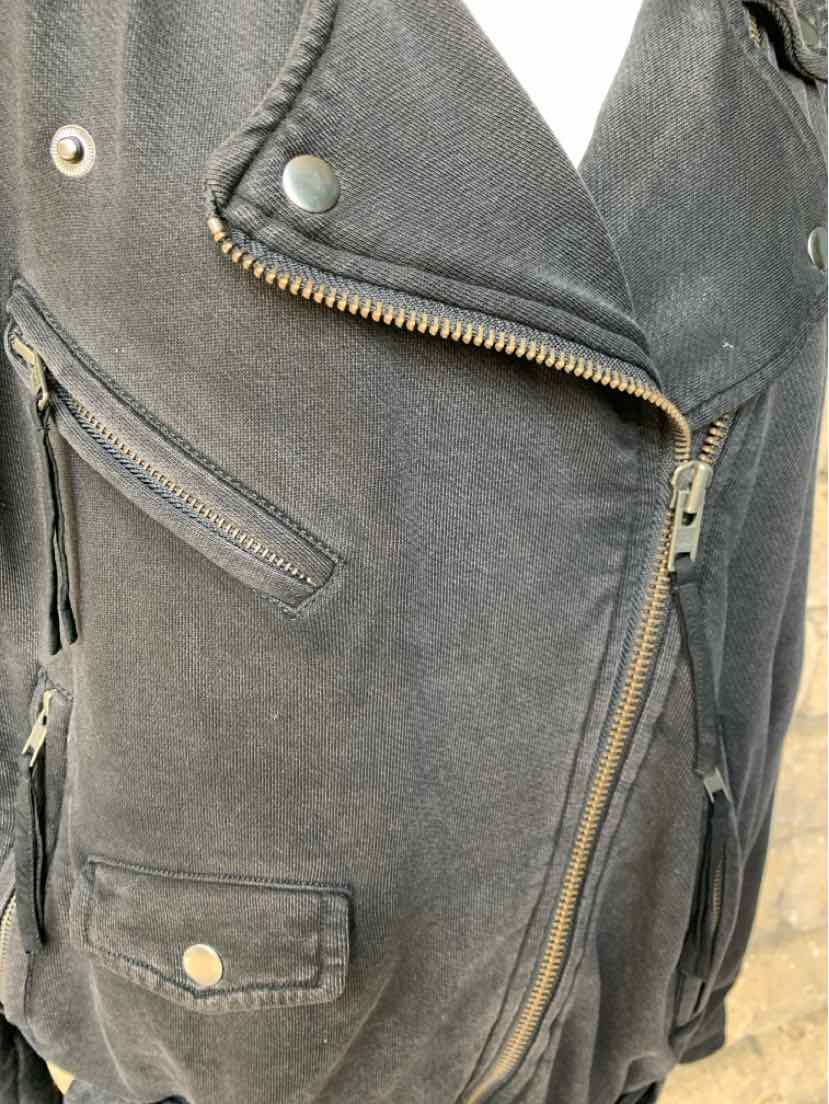 Black asymmetrical zip-up jacket with metal snap lapels and zippered pockets, soft textured fabric.