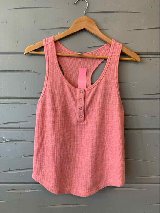 Pink sleeveless waffle knit henley tank top with scoop neck and button placket.