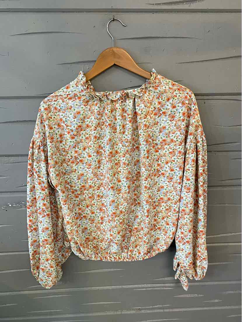 Long-sleeve blouse with orange and green floral print on white, gathered neckline and cuffs.