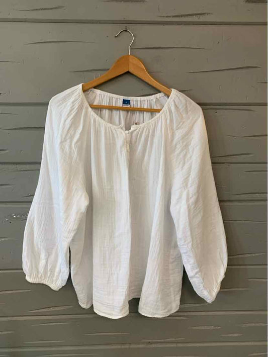 White long-sleeve blouse with gathered neckline and cuffs on wooden hanger.