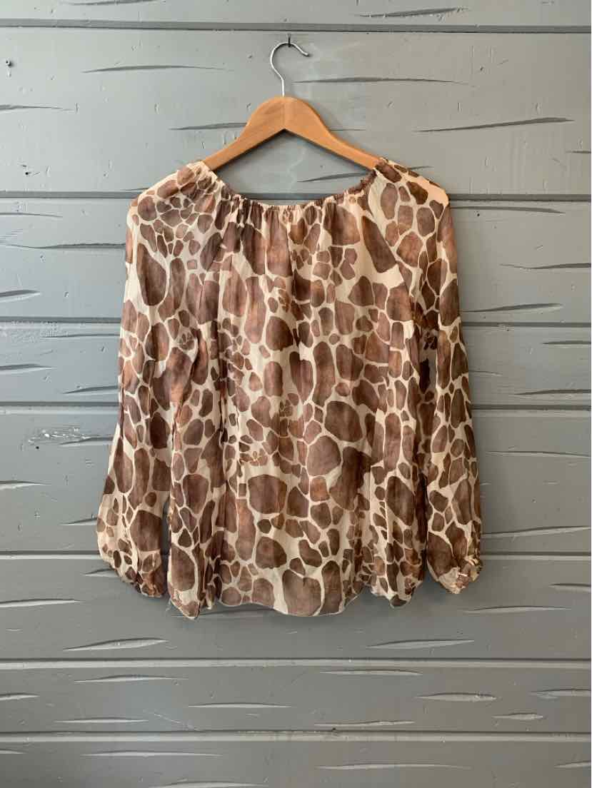Brown and beige giraffe print blouse with round neckline and long sleeves on wooden hanger.