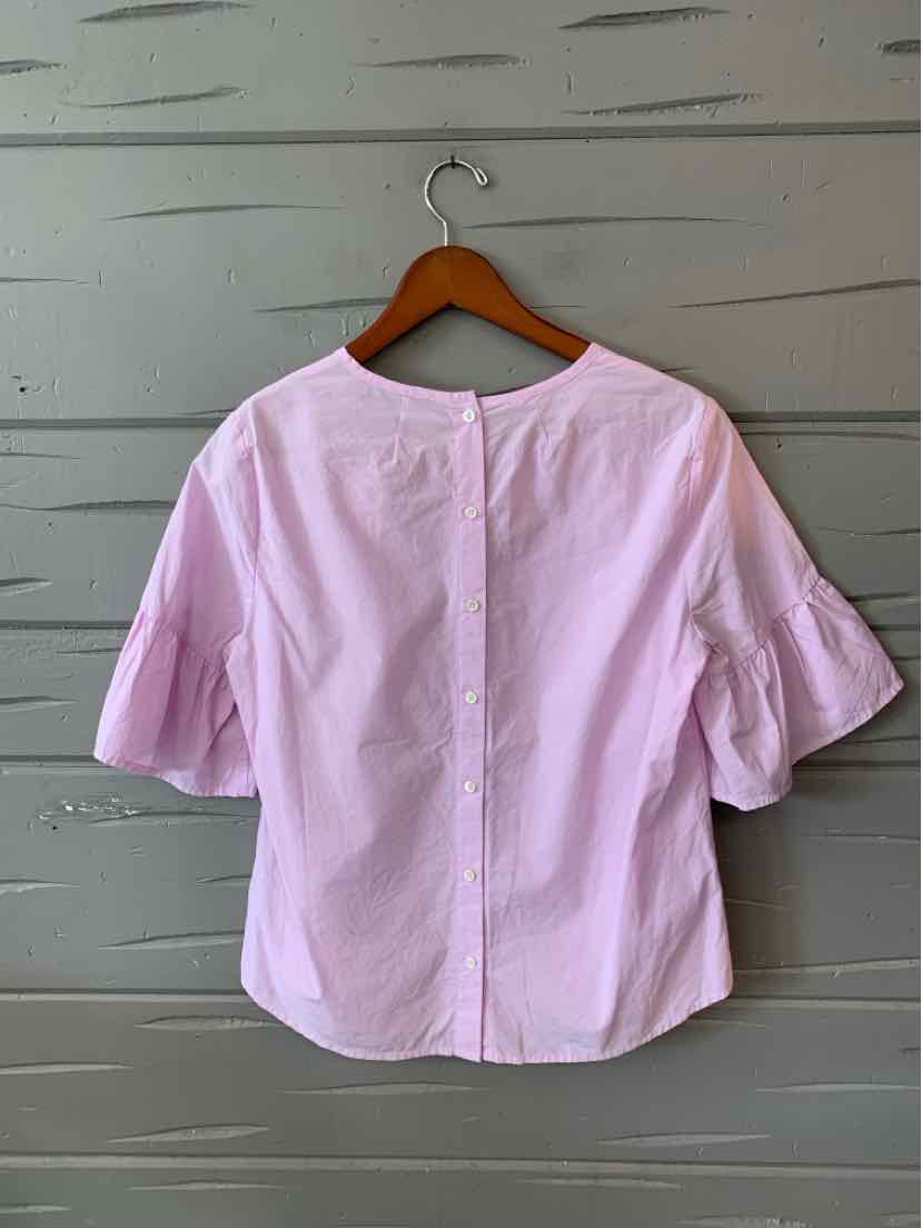 Light lavender blouse with elbow-length puff sleeves and back button closure hanging on wooden hanger.