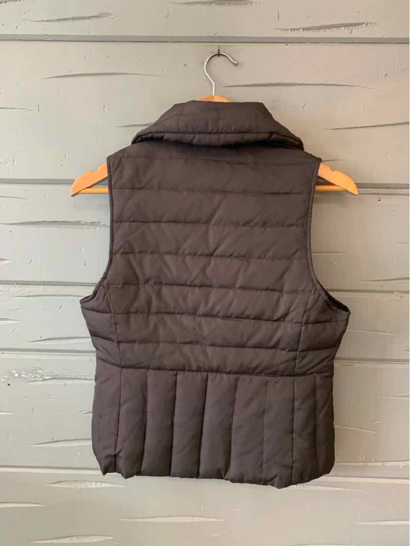 Black quilted sleeveless puffer vest with high collar and horizontal stitching.
