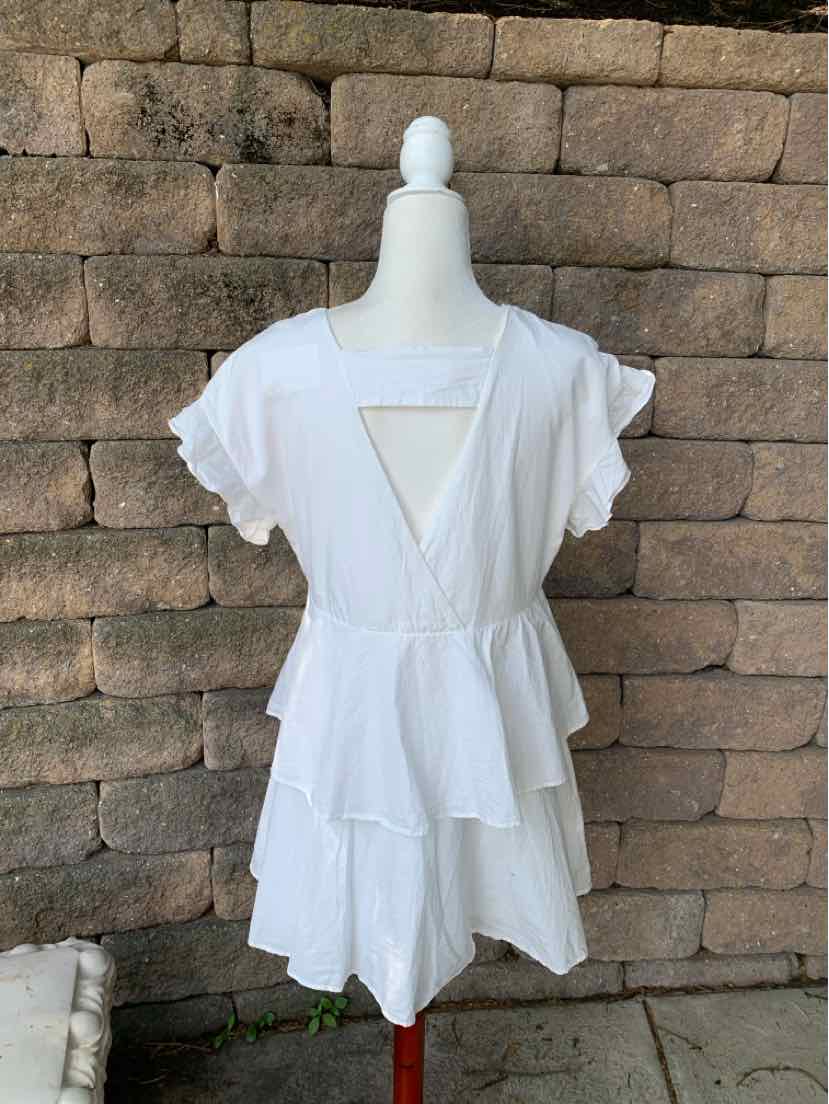 White short-sleeve dress with ruffled sleeves and tiered skirt, deep V neckline, and open back detail.