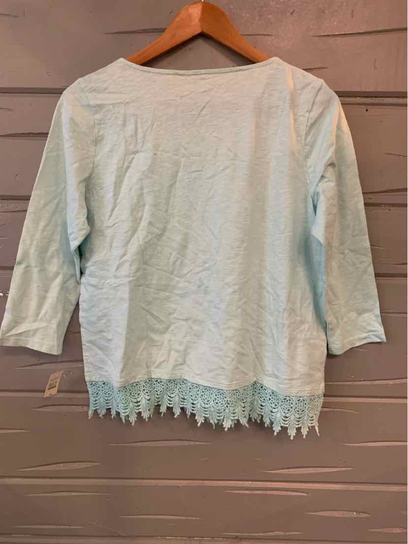 Light aqua long-sleeve top with scalloped lace hem hanging on wooden hanger.
