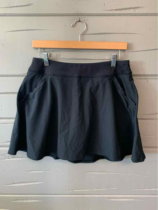 Black athletic skirt with elastic waistband and side pockets, lightweight fabric.