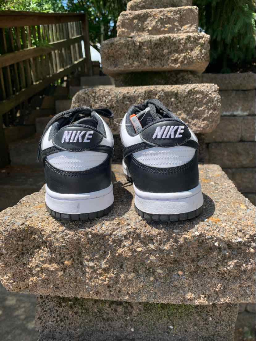 Black and white Nike sneakers with mesh and leather upper, visible Nike logo on heel, size 8.5.
