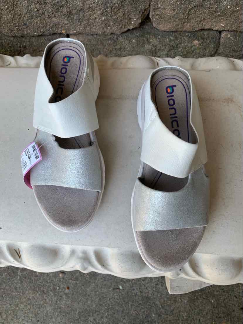 Women’s size 8.5 sandal with silver and white straps and cushioned footbed.