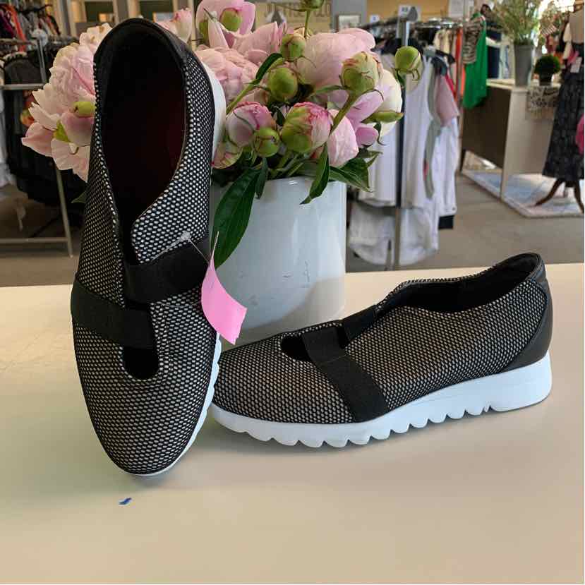 Black and gray mesh sneakers with white soles and elastic cross straps, size 9.