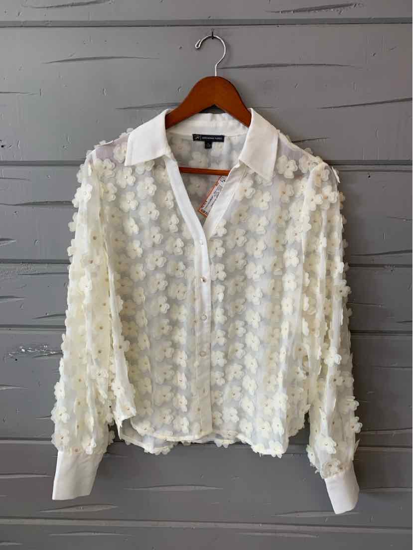 White floral textured blouse with collar, front zipper, and long cuffed sleeves.