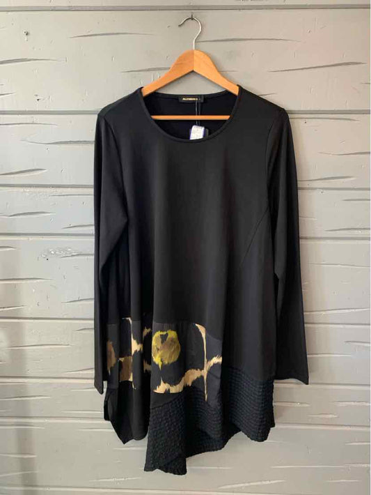 Black long-sleeve tunic with a rounded neckline, asymmetrical hem, and gold abstract accents near the bottom.