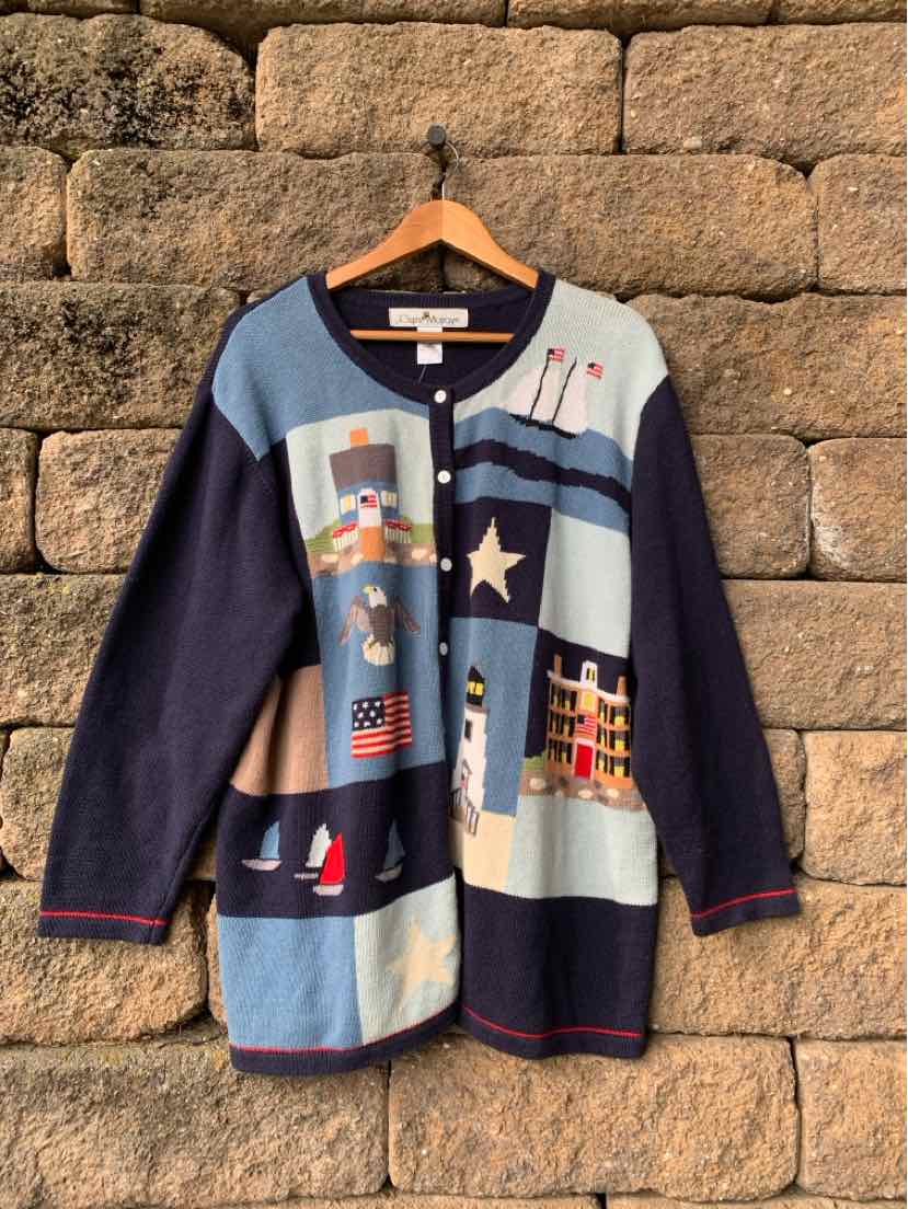 Women’s navy and pale blue patchwork cardigan with colorful appliqués, star details, and red trim.