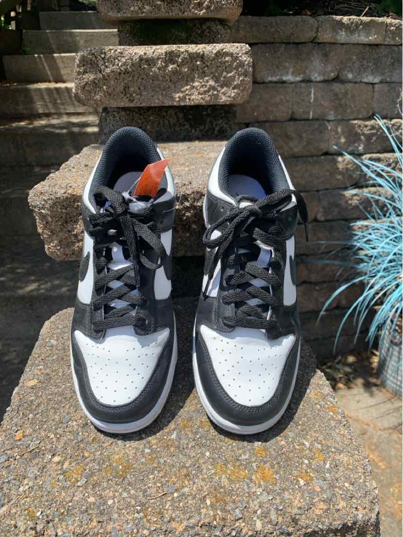 Black and white low-top Nike sneakers with black laces and a white perforated toe box, size 8.5.
