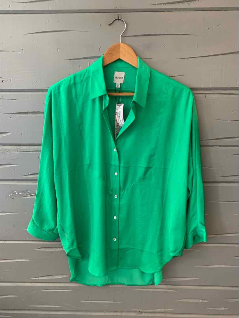 Bright green long-sleeve button-up blouse with collar, pocket, and relaxed fit on wooden hanger.