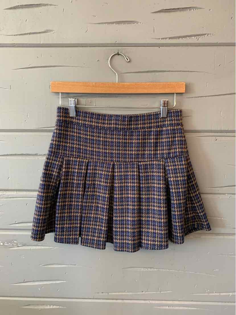 Navy blue pleated mini skirt with orange and white plaid pattern, fitted waistband, and flared hem.
