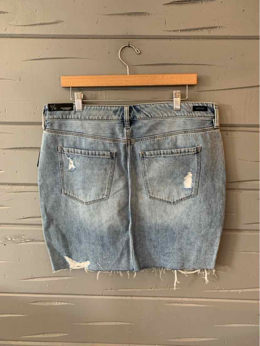 Light blue distressed denim skirt with frayed hem and back pockets hanging on wooden hanger.