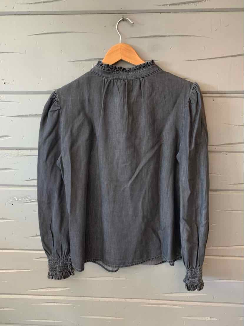 Long-sleeve dark gray blouse with high ruffled neckline and gathered cuffs hanging on wooden hanger.