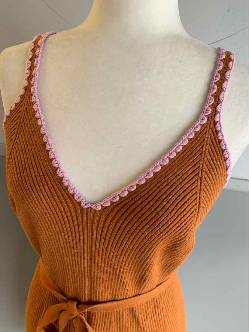 Tan ribbed knit tank top with pink scalloped trim and side tie detail.