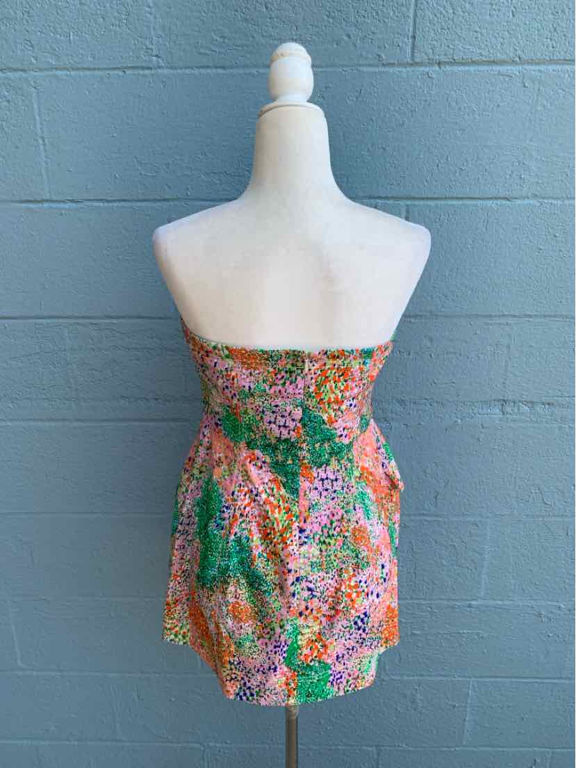 Strapless mini dress with vibrant multicolor floral pattern and smocked bodice.
