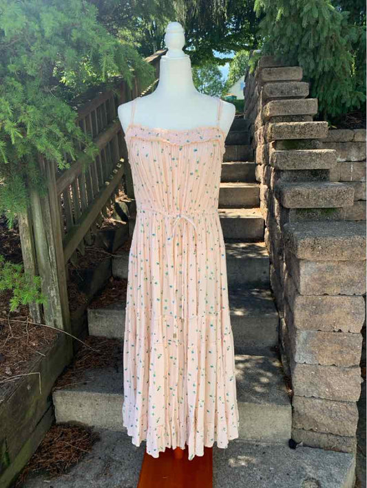 Light peach midi dress with small floral print, smocked bodice, thin adjustable straps, and pleated skirt.