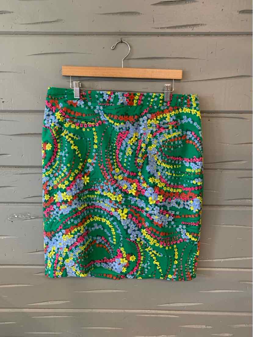 Green floral pencil skirt with multicolored spiral patterns, size 14, hanging on wooden hanger.