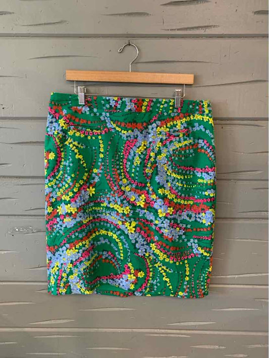Green floral pencil skirt with multicolored spiral patterns, size 14, hanging on wooden hanger.