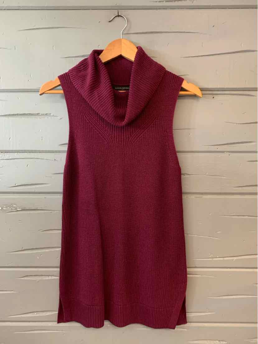 Sleeveless plum-colored knit dress with a wide cowl neck and straight silhouette hanging on wooden hanger.