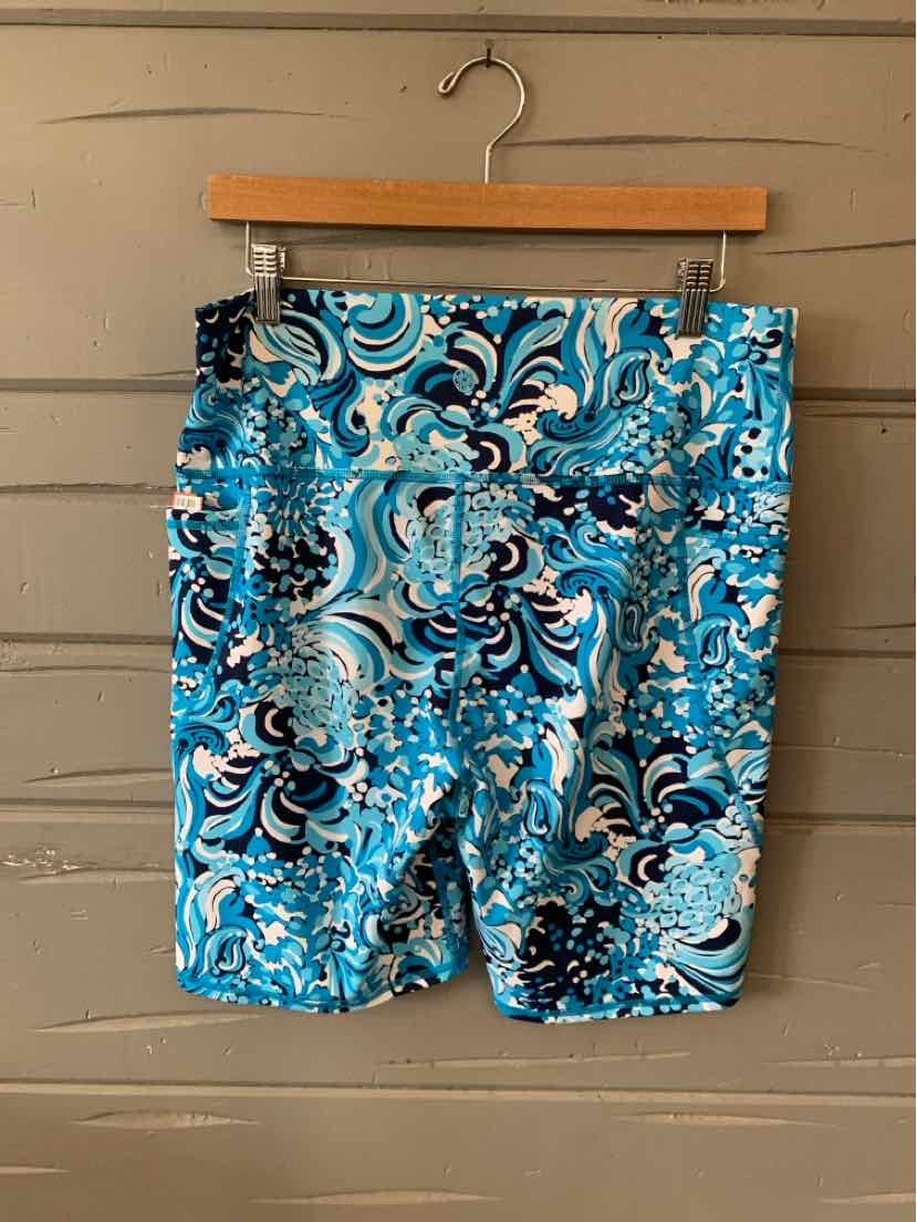 Blue and white paisley patterned shorts with an elastic waistband hanging on wooden hanger.