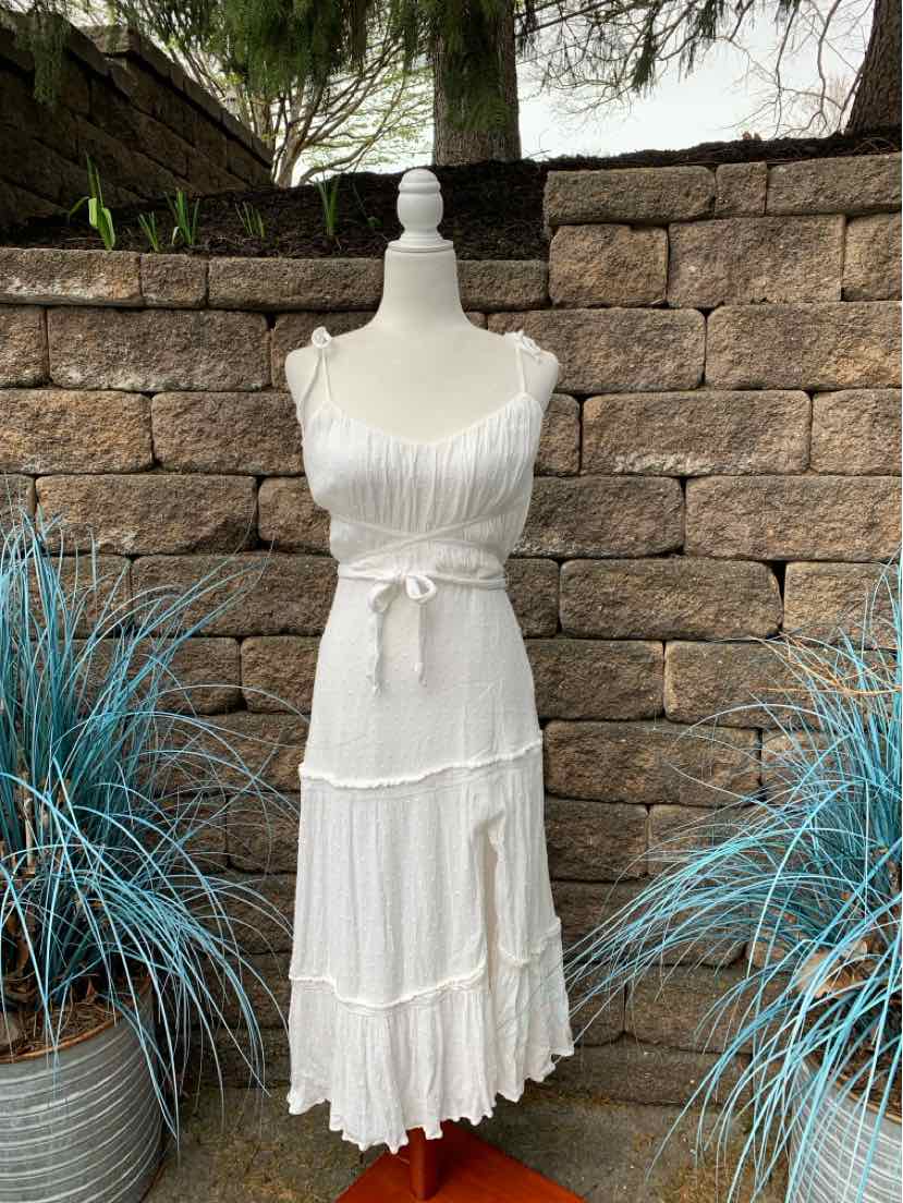 White sleeveless midi dress with ruffled straps and tiered skirt on mannequin.