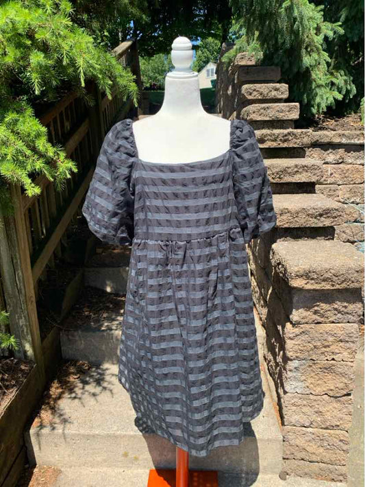 Black cotton dress with puffed short sleeves and horizontal stripe texture on mannequin outdoors.