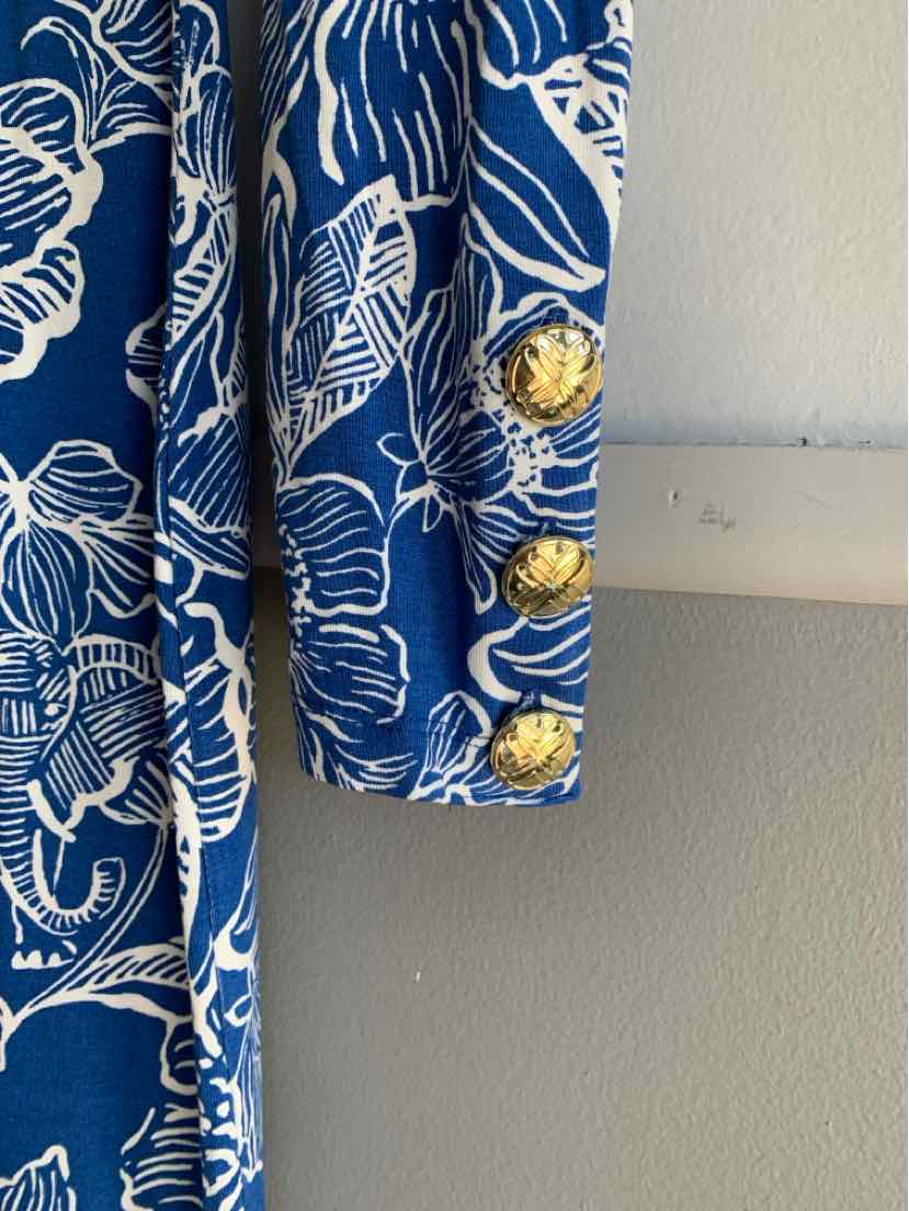 Blue dress sleeve with white tropical floral print and three gold decorative buttons on cuff.