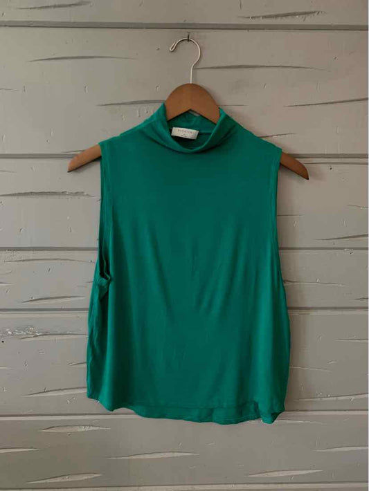 Sleeveless green mock neck blouse with a relaxed fit hanging on wooden hanger.