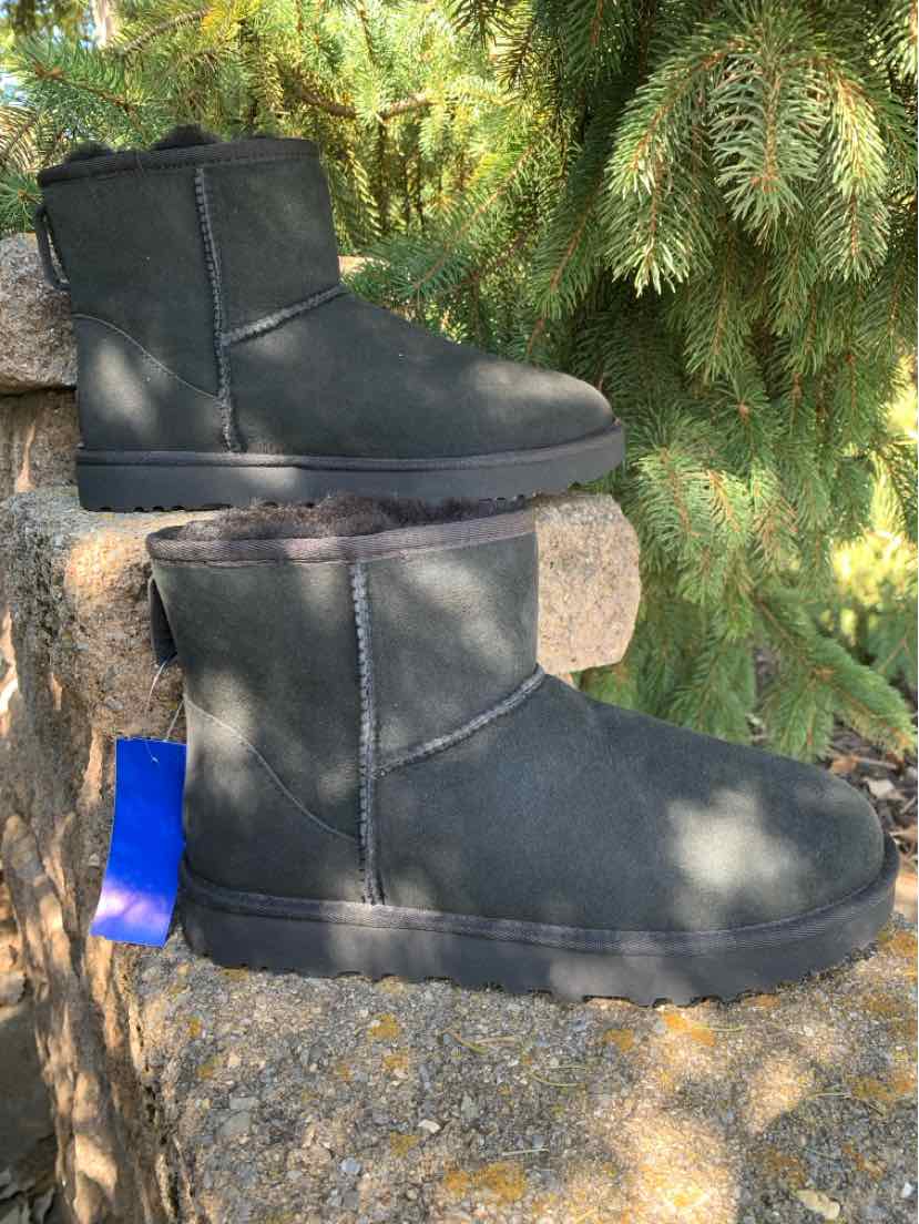 Pair of black suede UGG ankle boots with rounded toes, soft fleece lining, and flat soles.