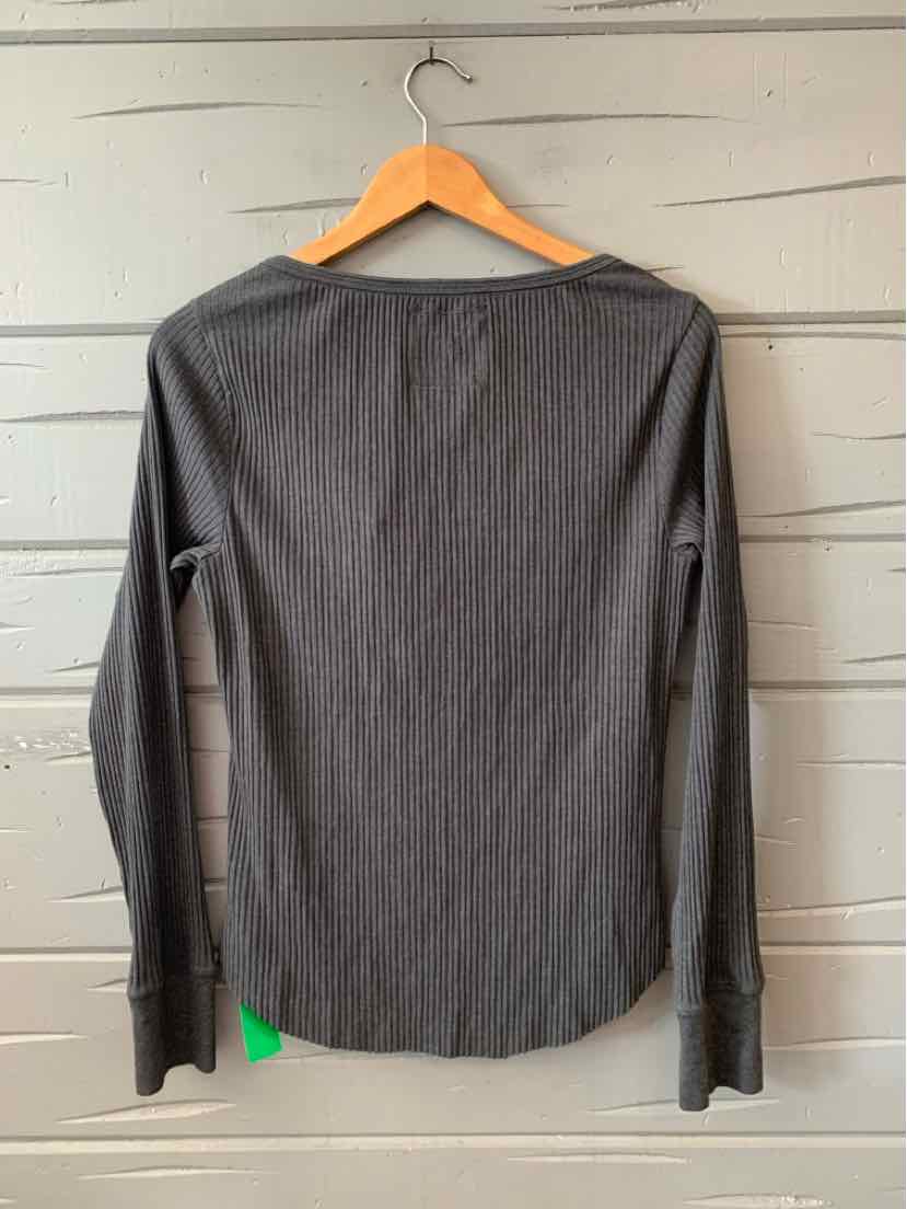 Long-sleeve solid gray top with a round neckline and slim fit hanging on wooden hanger.