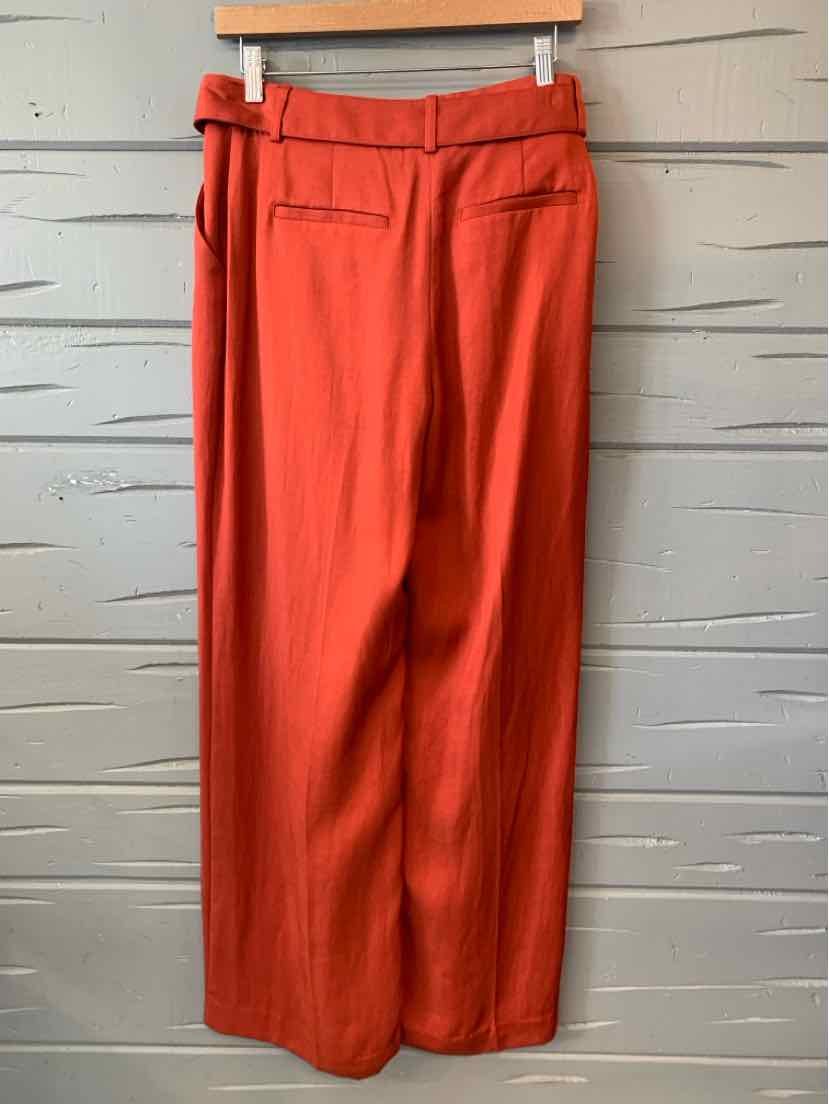 High-waisted solid orange wide-leg pants with a back flap pocket and belt loops.