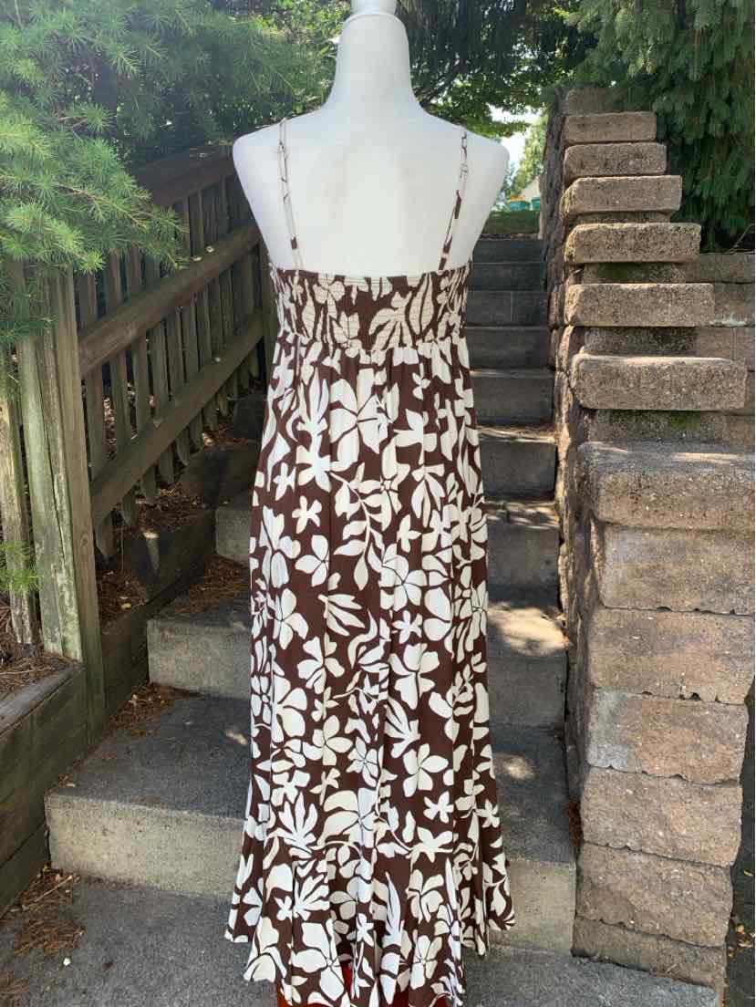 Brown and white floral print maxi dress with thin straps and ruffled hem.