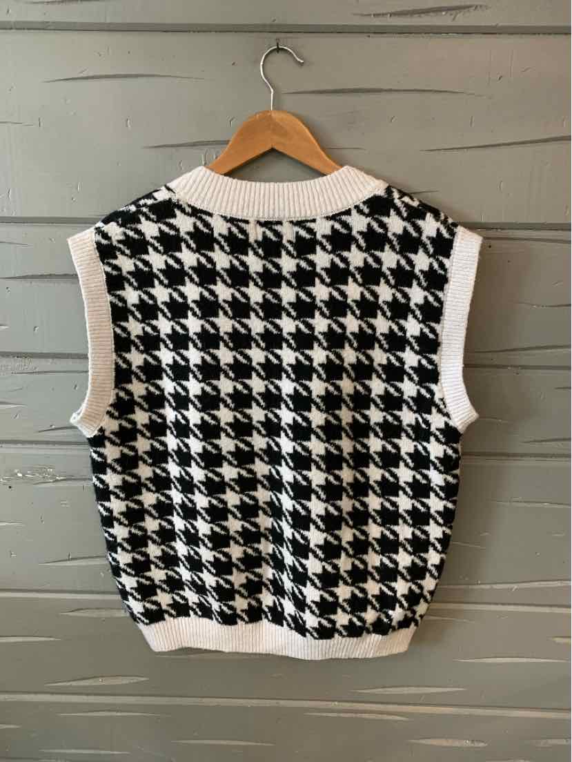 Black and white houndstooth sleeveless sweater vest with white ribbed trim, medium size.