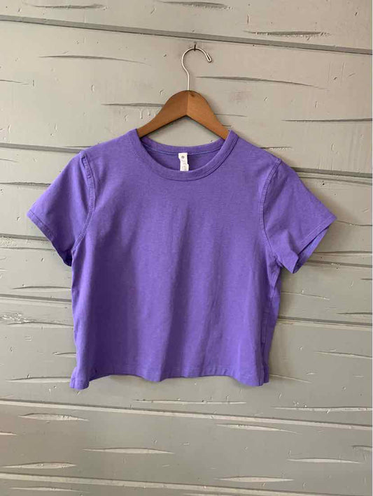 Lavender short-sleeve cropped T-shirt with crew neck on wooden hanger.