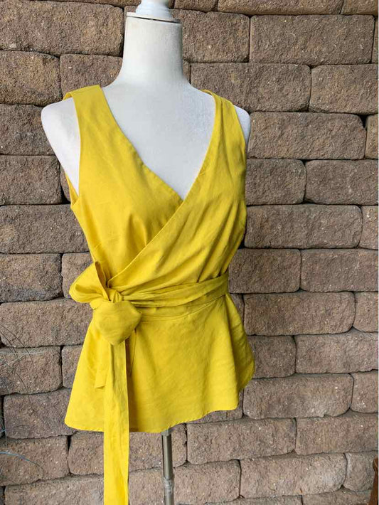 Yellow sleeveless wrap blouse with V-neck and side tie waist in soft fabric.