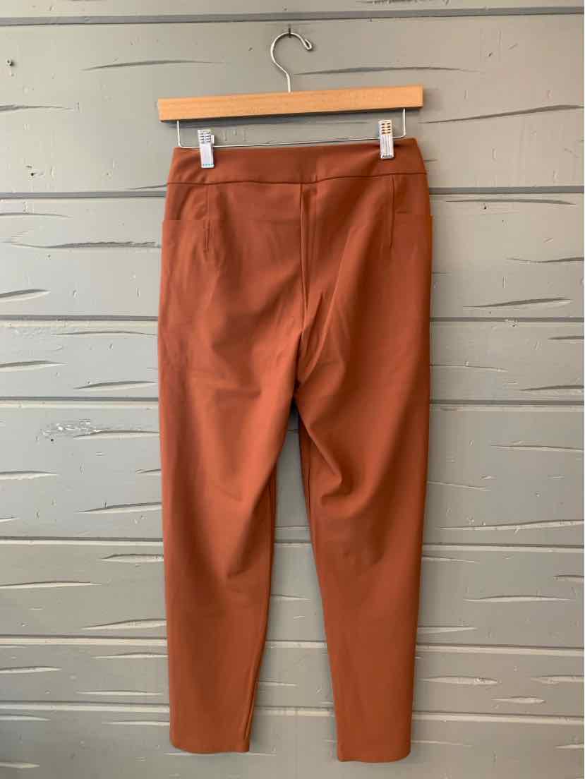 Rust-orange Athleta women’s leggings with a smooth finish, wide waistband, and tapered full-length legs.
