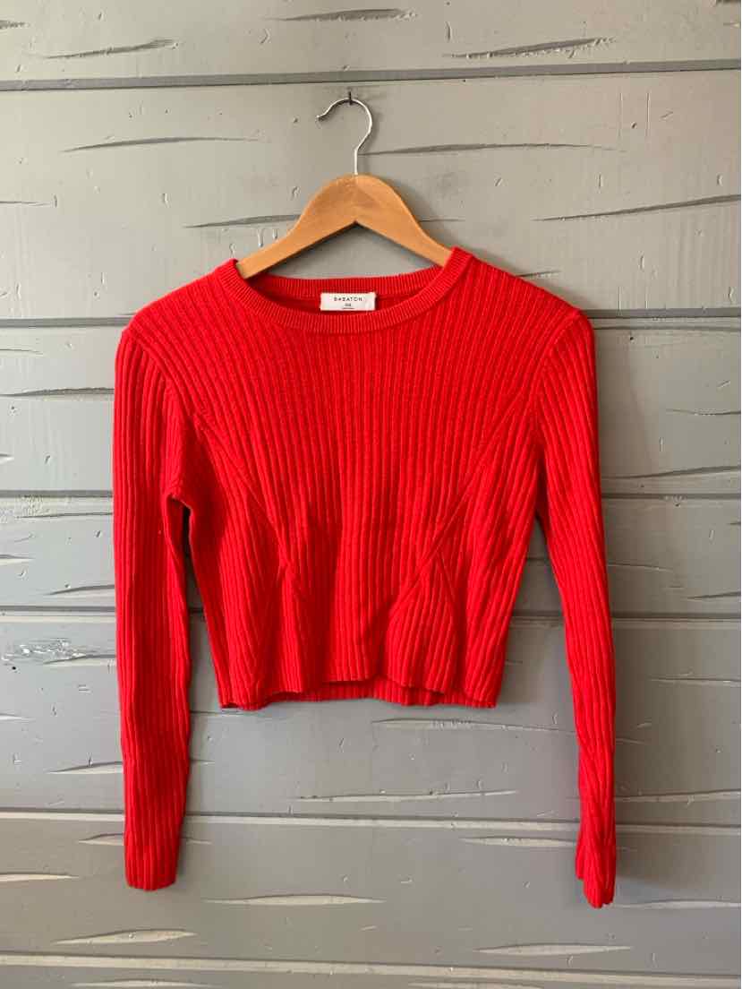 Bright red ribbed knit long-sleeve crop top with crew neckline on wooden hanger.